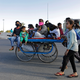A migrant worker rides a cart with his family on a highway as they return to their villages, during a 21-day nationwide lockdown to limit the spreading of coronavirus disease (COVID-19), in Ghaziabad